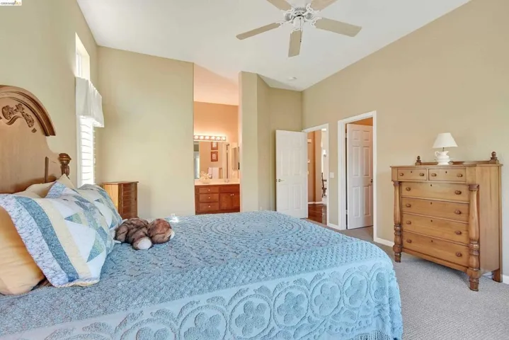 Bedroom featuring carpet flooring, ceiling fan, and connected bathroom