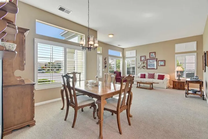 Dining area featuring light colored carpet and a chandelier