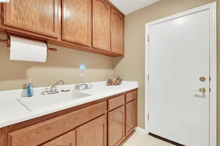 Laundry area featuring a sink and light flooring