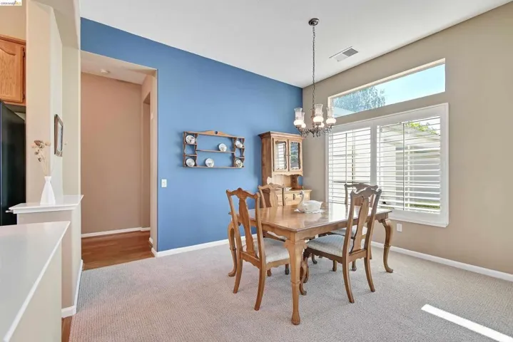 Dining area featuring light colored carpet and a chandelier