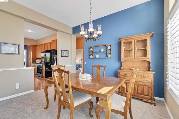 Dining area with healthy amount of natural light, a chandelier, and light colored carpet