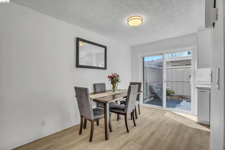 Dining area featuring a textured ceiling and light wood-style flooring