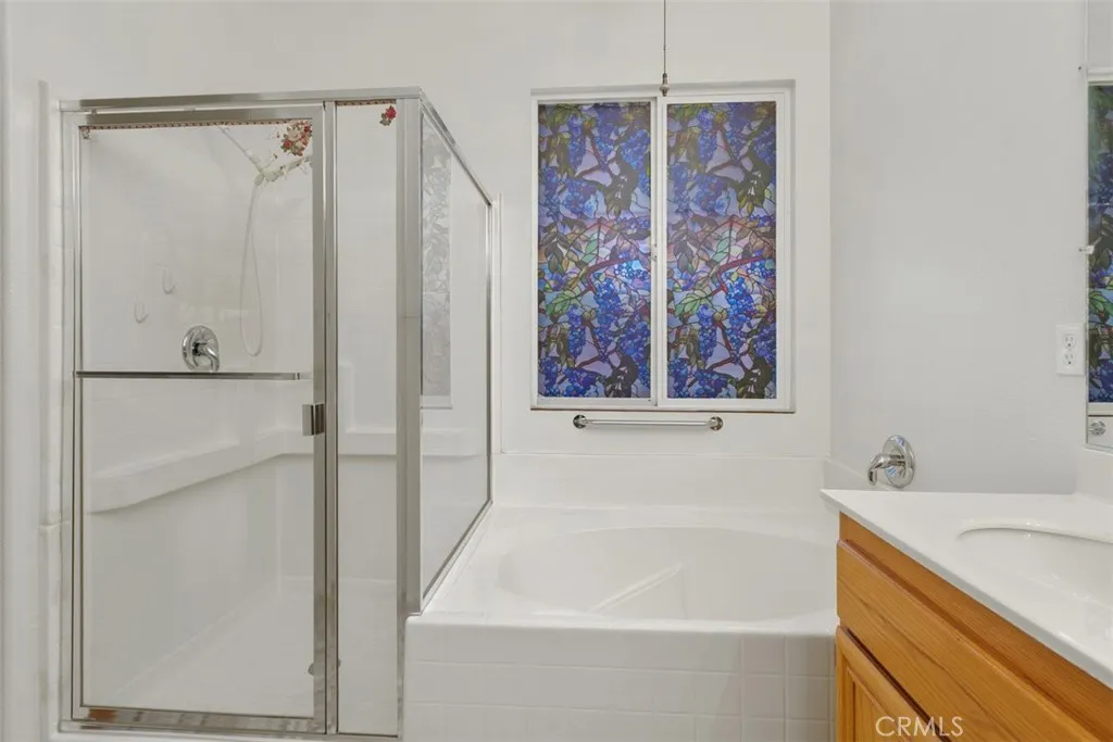 Primary bathroom has a soaking tub, shower, dual sink vanity, and water closet for privacy.