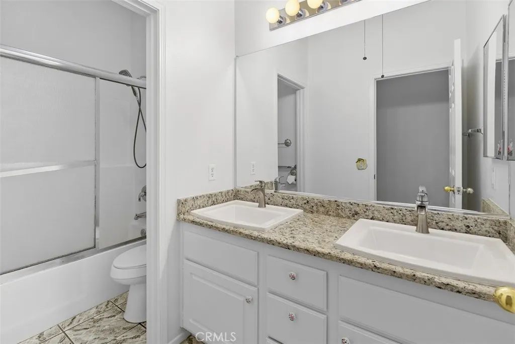 The hall bathroom has a dual sink vanity and shower-over-tub.