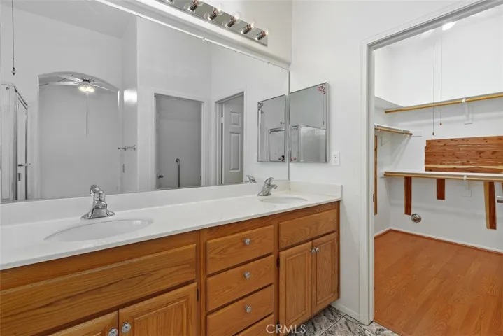 Primary bathroom vanity w/view of walk-in closet.