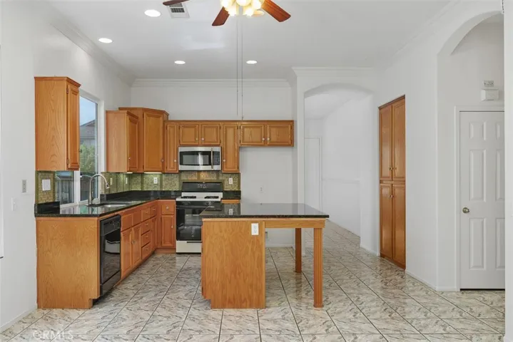 View of the kitchen w/pantry, and one of two hall closets and a view toward front entry.