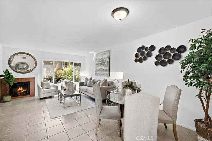 Living room with fireplace, dual pane window, formal dining area, and title flooring