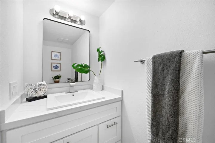 Remodeled half bathroom with new vanity, quartz countertop, new light fixture