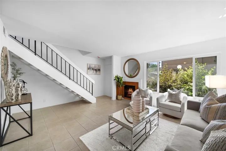 Entry door, staircase to second floor, and living room