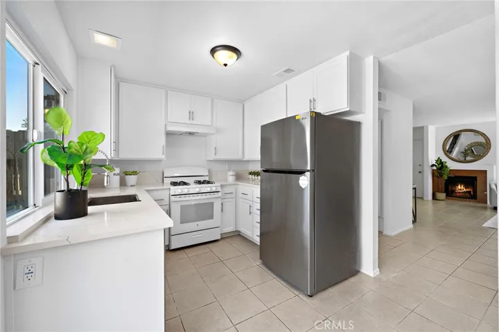Beautifully remodeled quartz kitchen with custom white shaker cabinetry