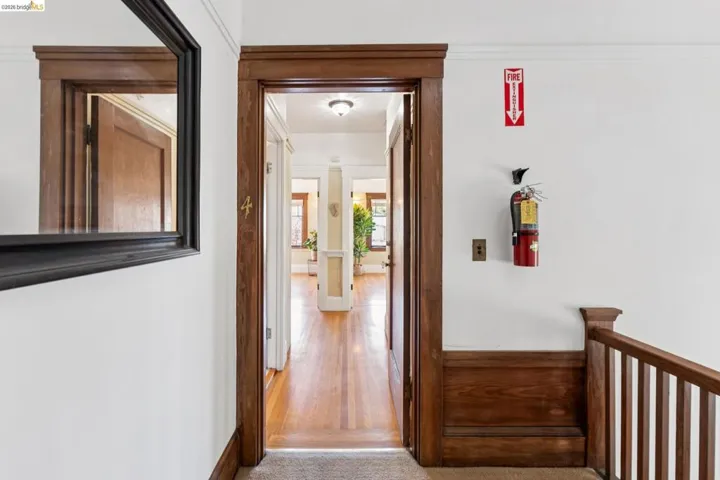 Hallway featuring light colored carpet