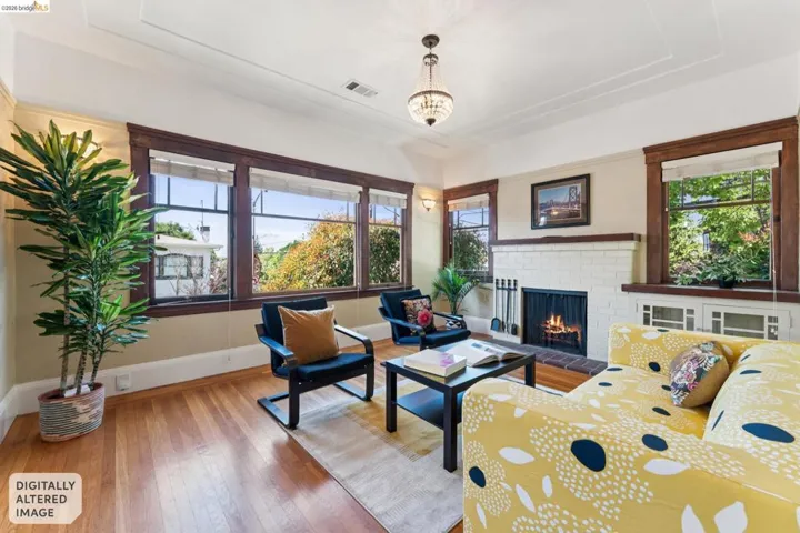 Living room featuring a brick fireplace, light wood-style flooring, and a chandelier