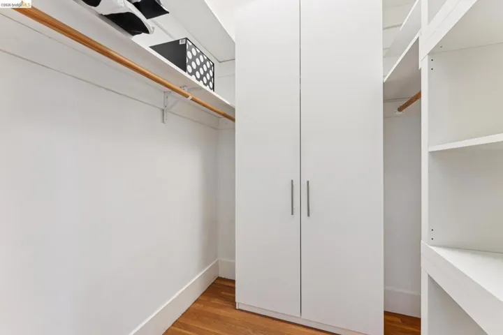Walk in closet with light wood finished floors