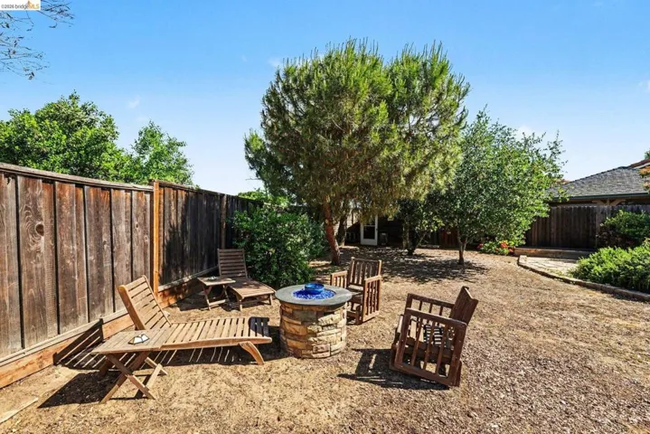 Fenced backyard with an outdoor fire pit and a patio area
