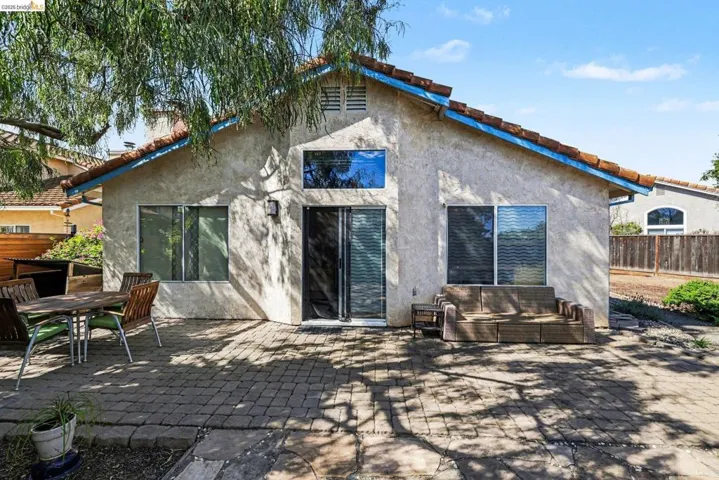 Rear view of house with a patio, stucco siding, and a tile roof