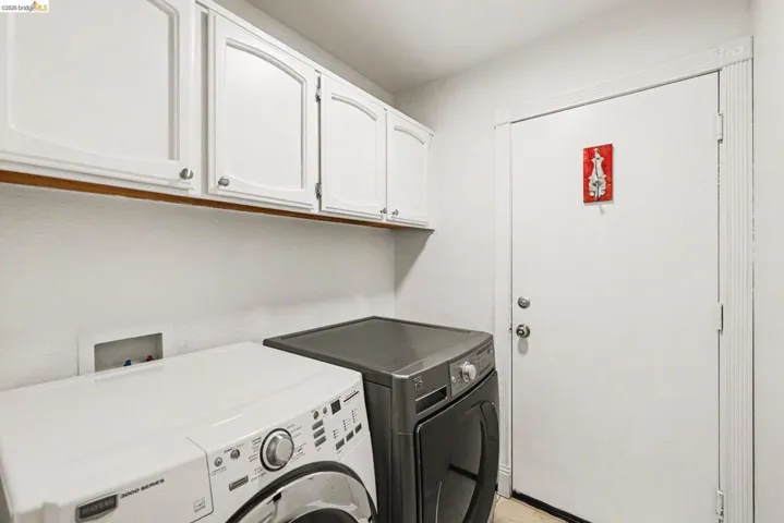 Laundry room with separate washer and dryer and cabinet space
