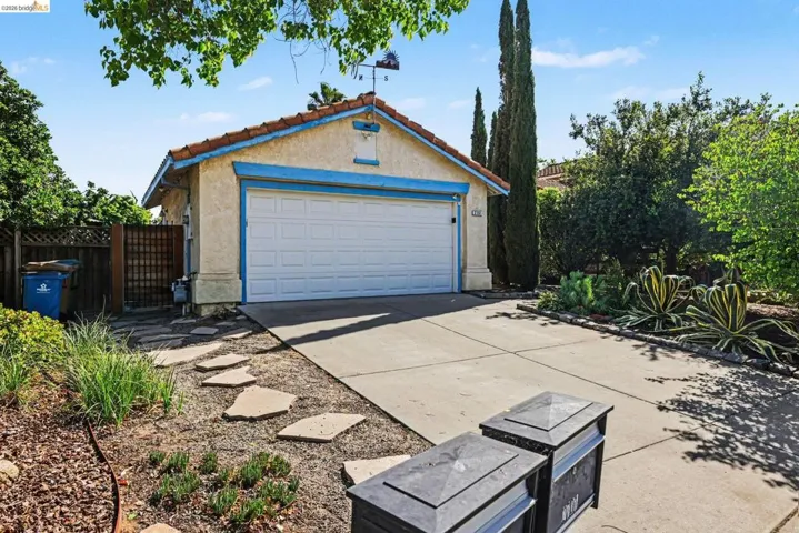 Garage featuring concrete driveway and a gate