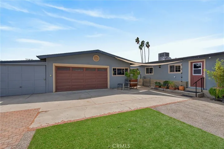 This view showcases the double car and single car garages. The windows on the right are part of the additional studio space.
