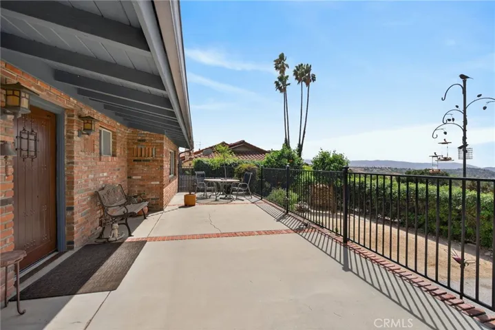 The front porch runs the entire length of the home. Notice the brick accents and custom solid wood front door.