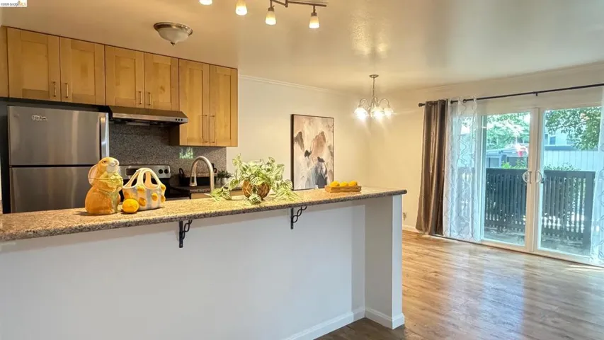 Kitchen featuring stainless steel appliances, backsplash, a peninsula, light stone counters, and a breakfast bar area