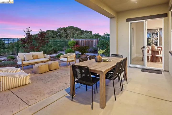Patio terrace at dusk with a patio, a fenced backyard, and outdoor lounge area