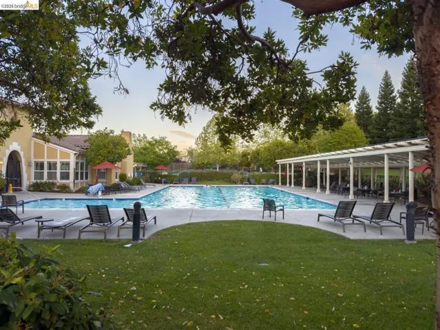 Community pool with a patio area and a lawn
