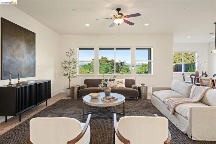Living room featuring a ceiling fan, plenty of natural light, and recessed lighting