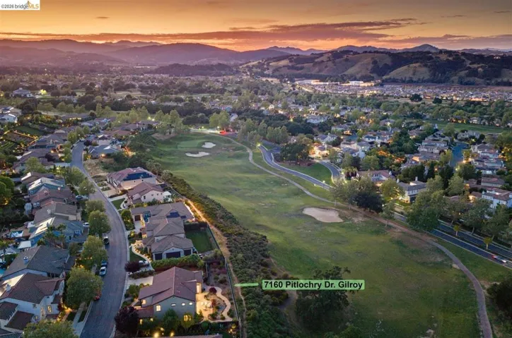 Aerial view of residential area with a golf club and mountains