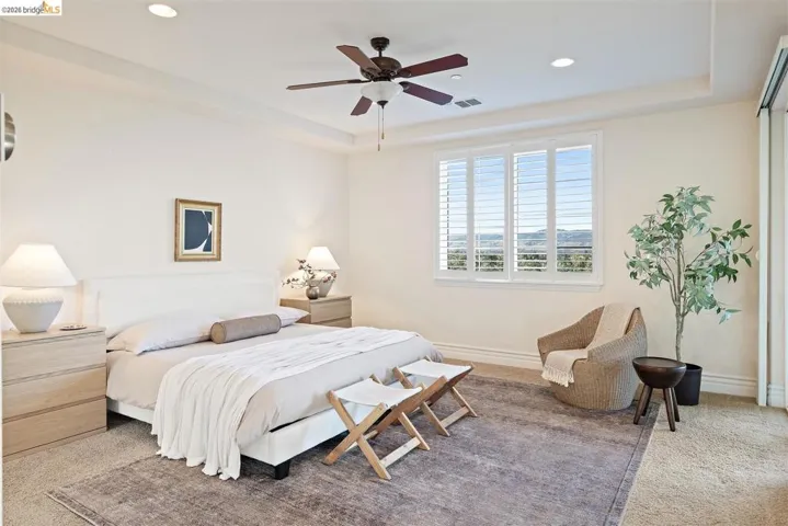 Bedroom with a tray ceiling, recessed lighting, ceiling fan, and carpet flooring
