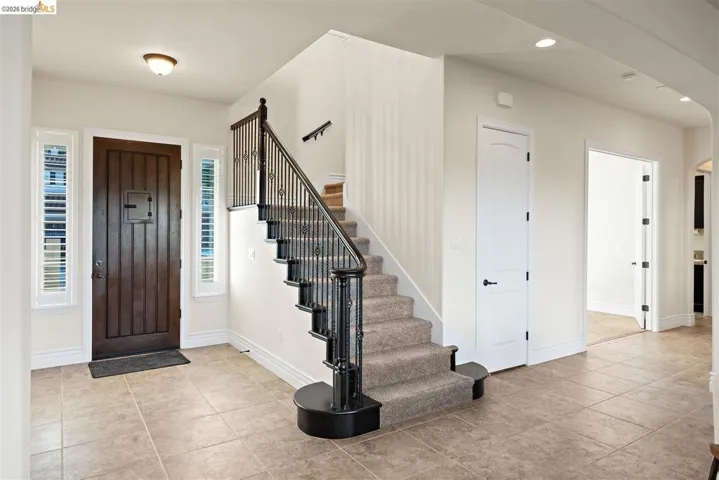 Foyer with light tile patterned flooring, arched walkways, and recessed lighting