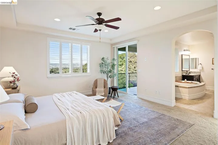 Bedroom with arched walkways, light carpet, access to outside, a ceiling fan, and recessed lighting