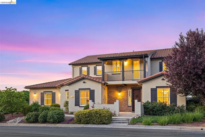 Mediterranean / spanish-style house featuring a balcony, stucco siding, and a tile roof