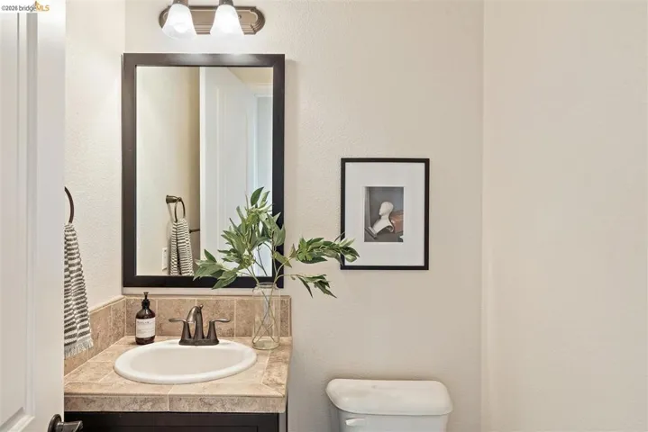 Bathroom featuring a textured wall and vanity