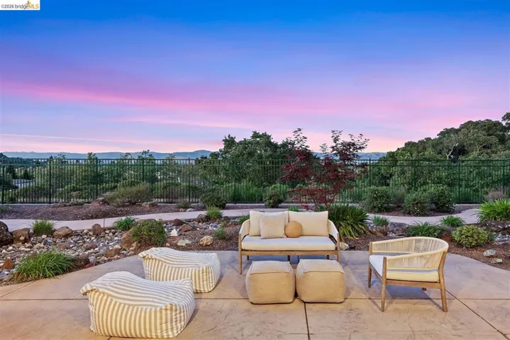 Patio terrace at dusk with a fenced backyard, a patio, a mountain view, and outdoor lounge area