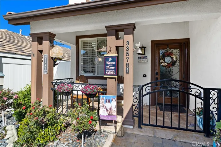 Charming Covered Front Porch With Decorative Accents And Seating Area