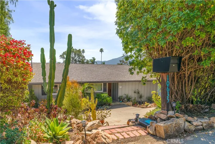 Private entry surrounded by lush, mature landscaping and succulents.