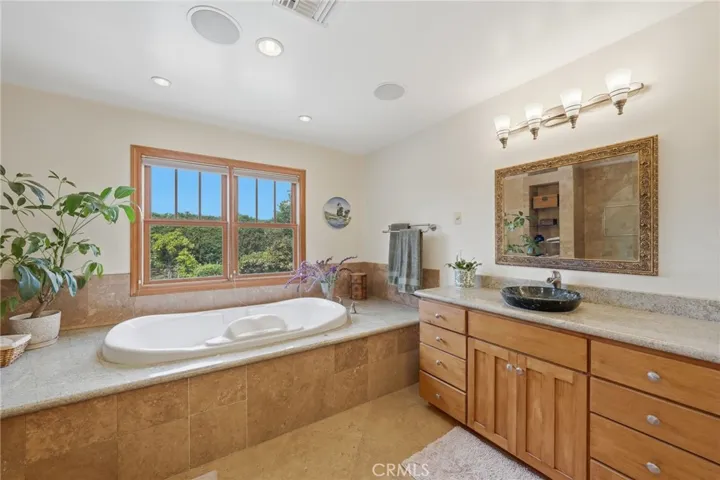 Master bath complete with 2 separate sinks, and travertine floor and shower walls.