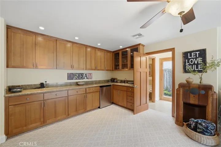 Large wet bar in bonus/game room. Attached full bath with tile floors and access to outside for swim days and wet feet.
