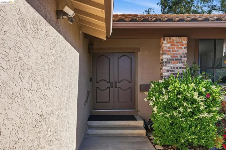 Doorway to property featuring stucco siding and a tiled roof