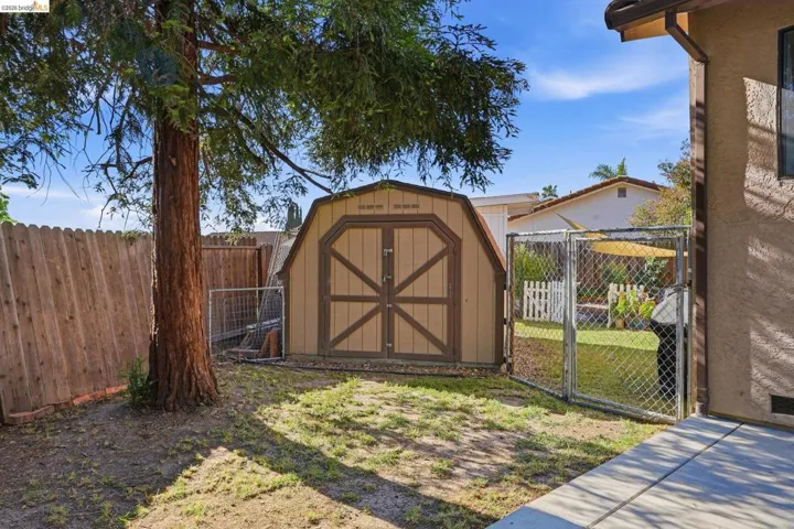 View of shed featuring a fenced backyard and a gate