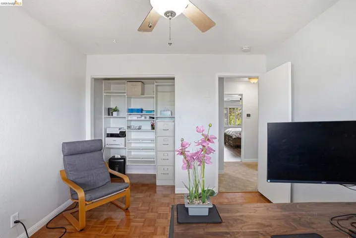 Sitting room with parquet flooring, a ceiling fan, and a textured ceiling