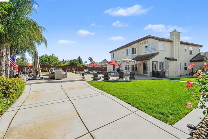 Back of house featuring a patio, a swimming pool, a fenced backyard, and stucco siding