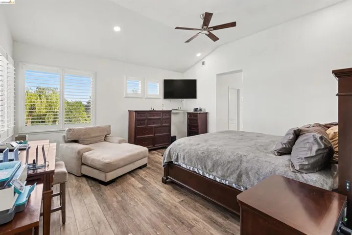 Bedroom featuring light wood-type flooring, recessed lighting, ceiling fan, and vaulted ceiling