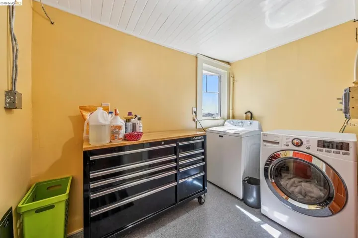 Laundry room with separate washer and dryer and wood ceiling