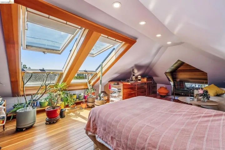 Bedroom featuring recessed lighting, wood-type flooring, vaulted ceiling, and a skylight