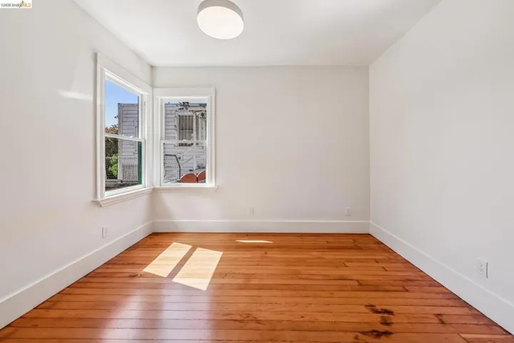 Spare room featuring light wood-style flooring and baseboards
