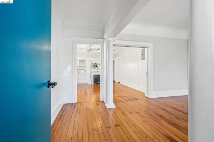 Corridor with ornate columns and light wood-style floors