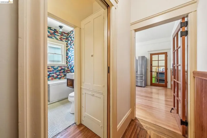 Hallway with light wood-type flooring and french doors
