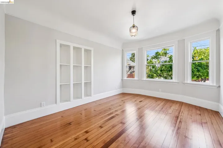 Spare room featuring light wood-style flooring and baseboards