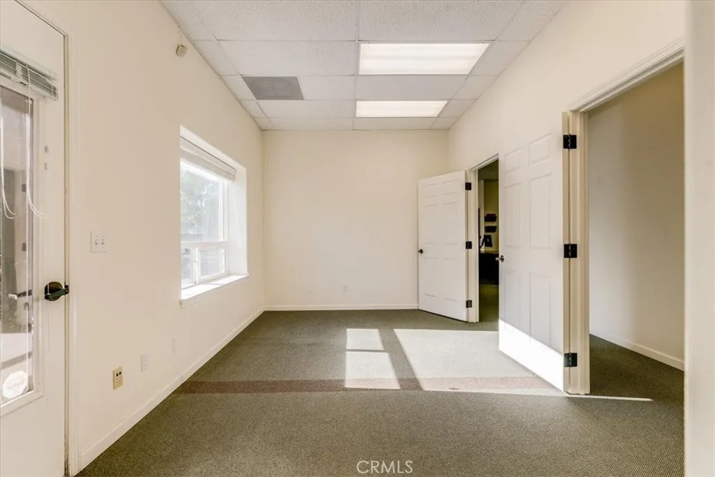 Large office with exterior entrance and two doors into interior hallway